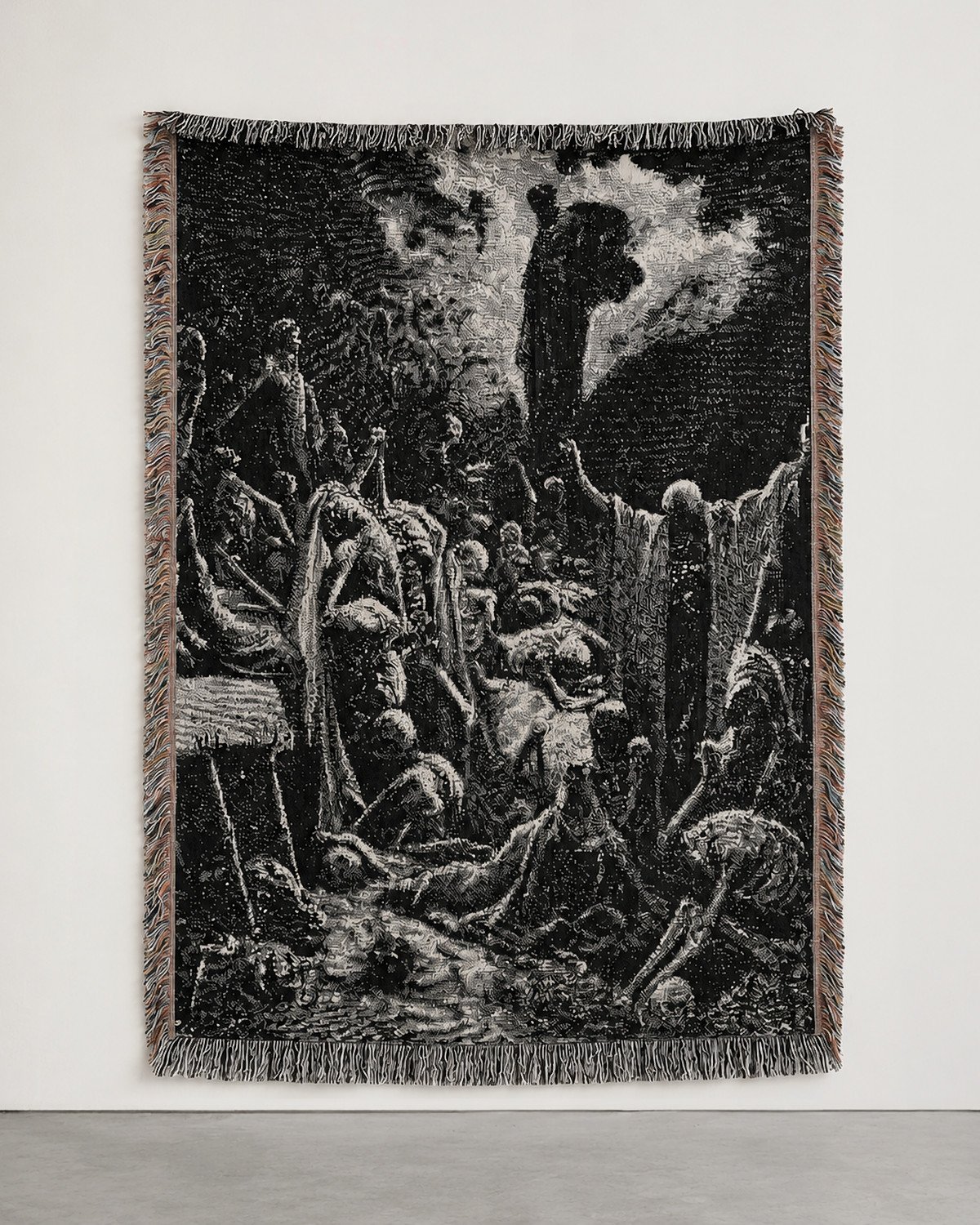 Valley of Dry Bones woven blanket hung on a white gallery wall: a black and white engraving of the prophet above a valley of rising bodies.