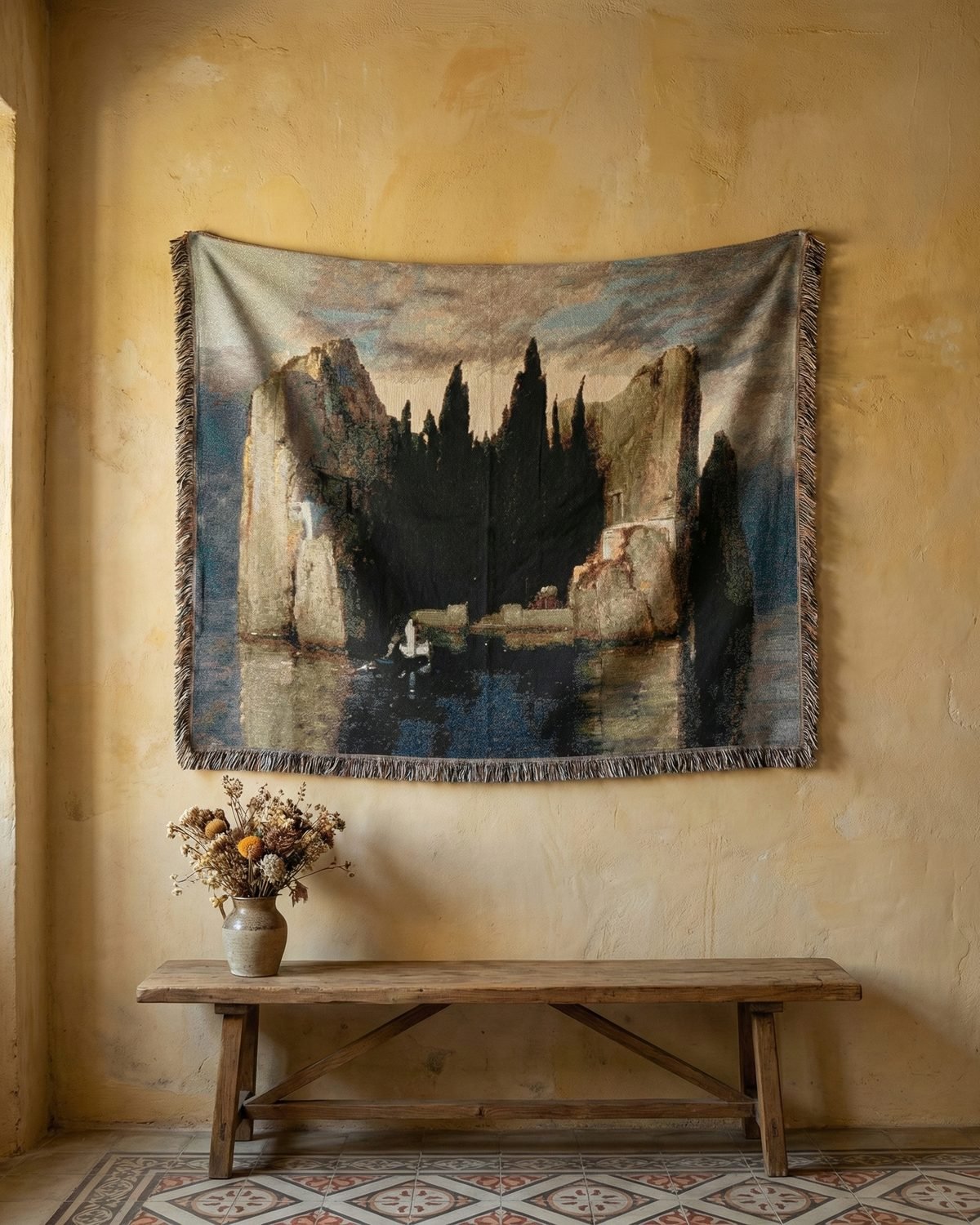 Isle of the Dead blanket hung on a warm plaster wall above a wooden bench.