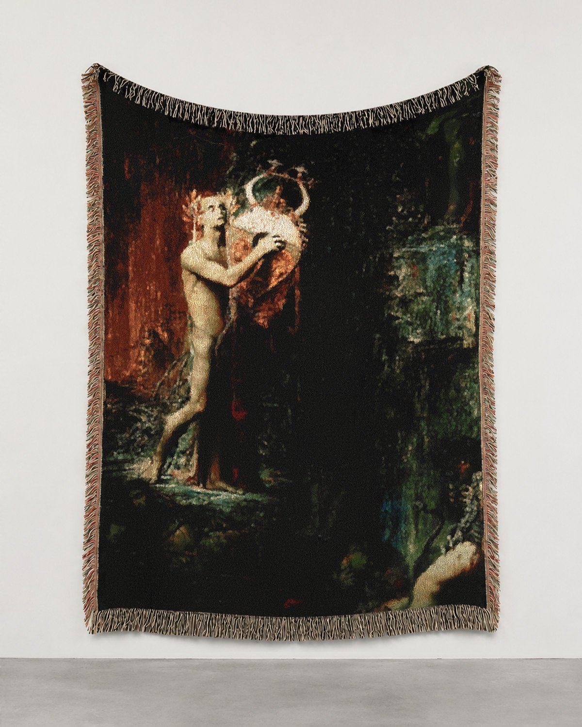 Orpheus in Hades woven blanket hung on a white gallery wall: a pale Orpheus holding a gold lyre close to his head, copper-red and green shapes on black.