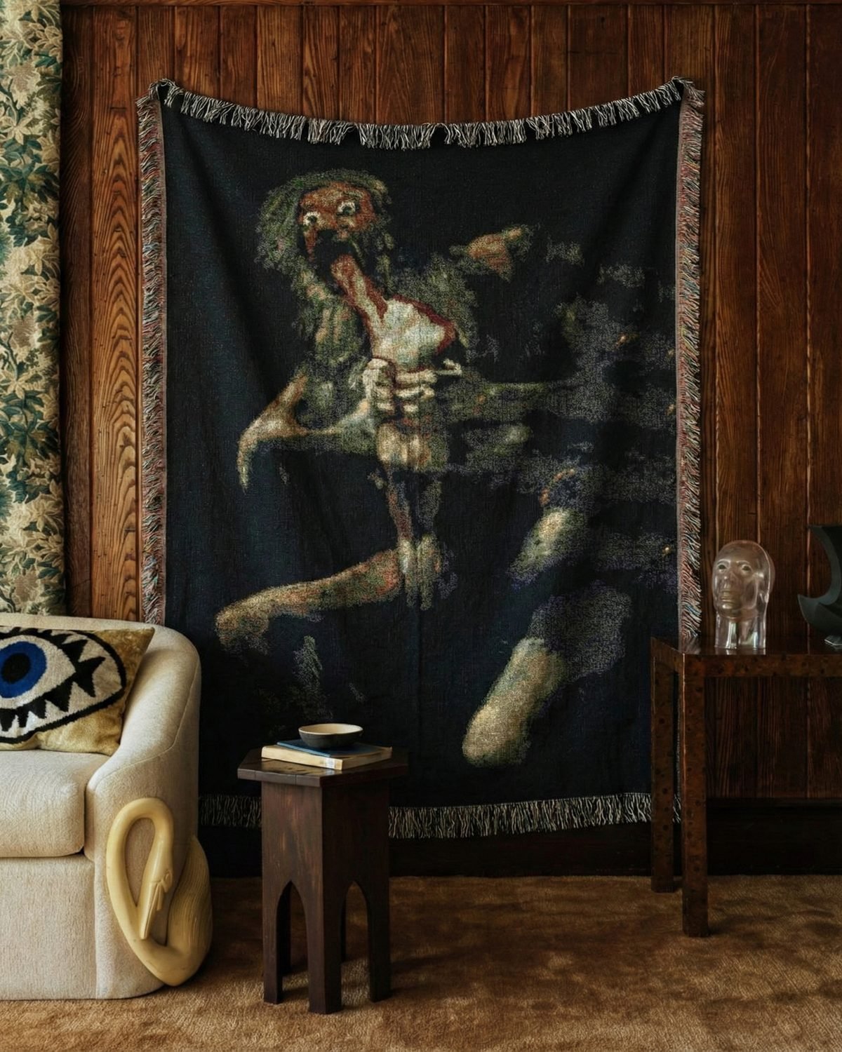 Saturn blanket hung on a wood-paneled wall beside a cream armchair.
